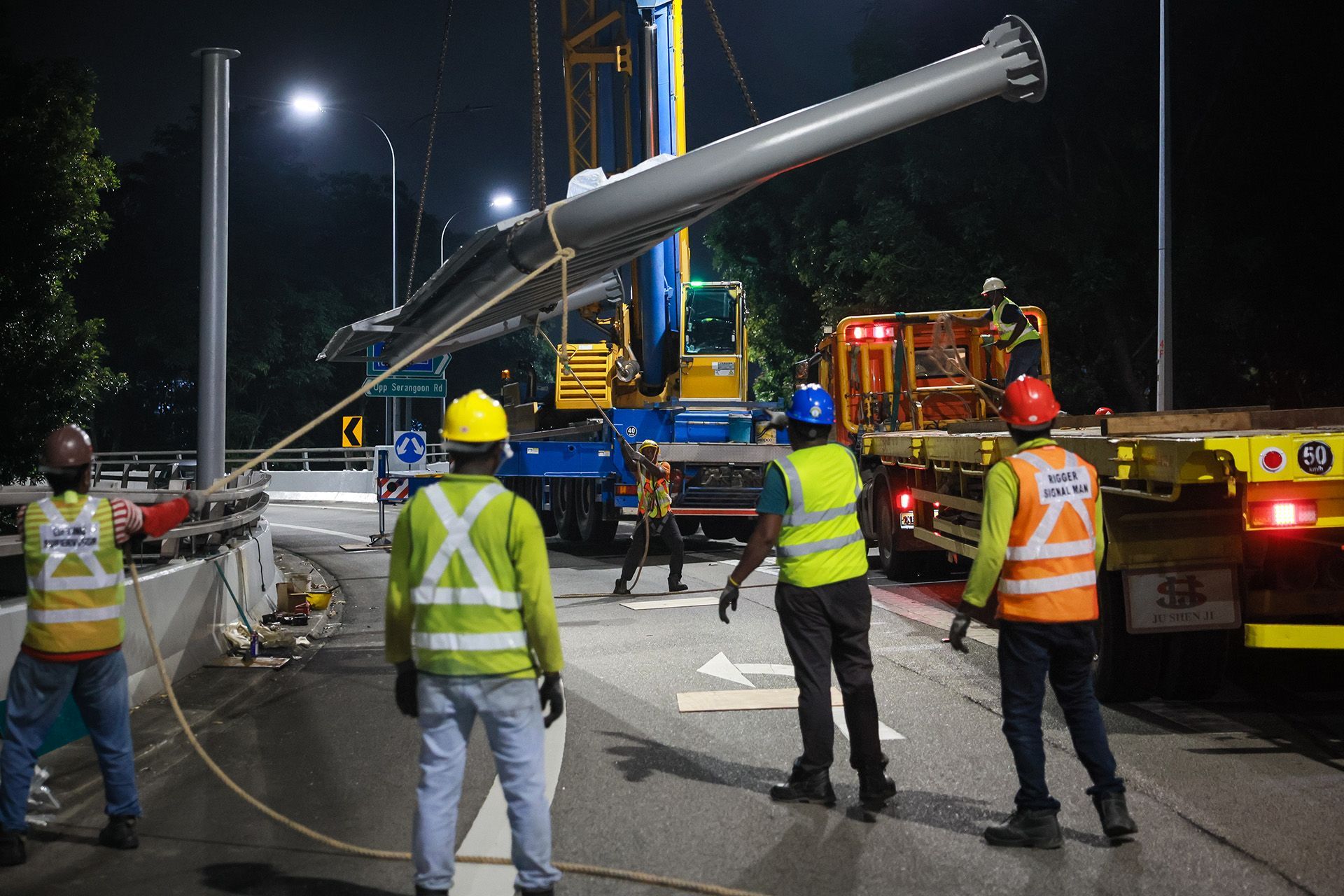 The new overhead gantry is unloaded from a trailer with the help of cranes.