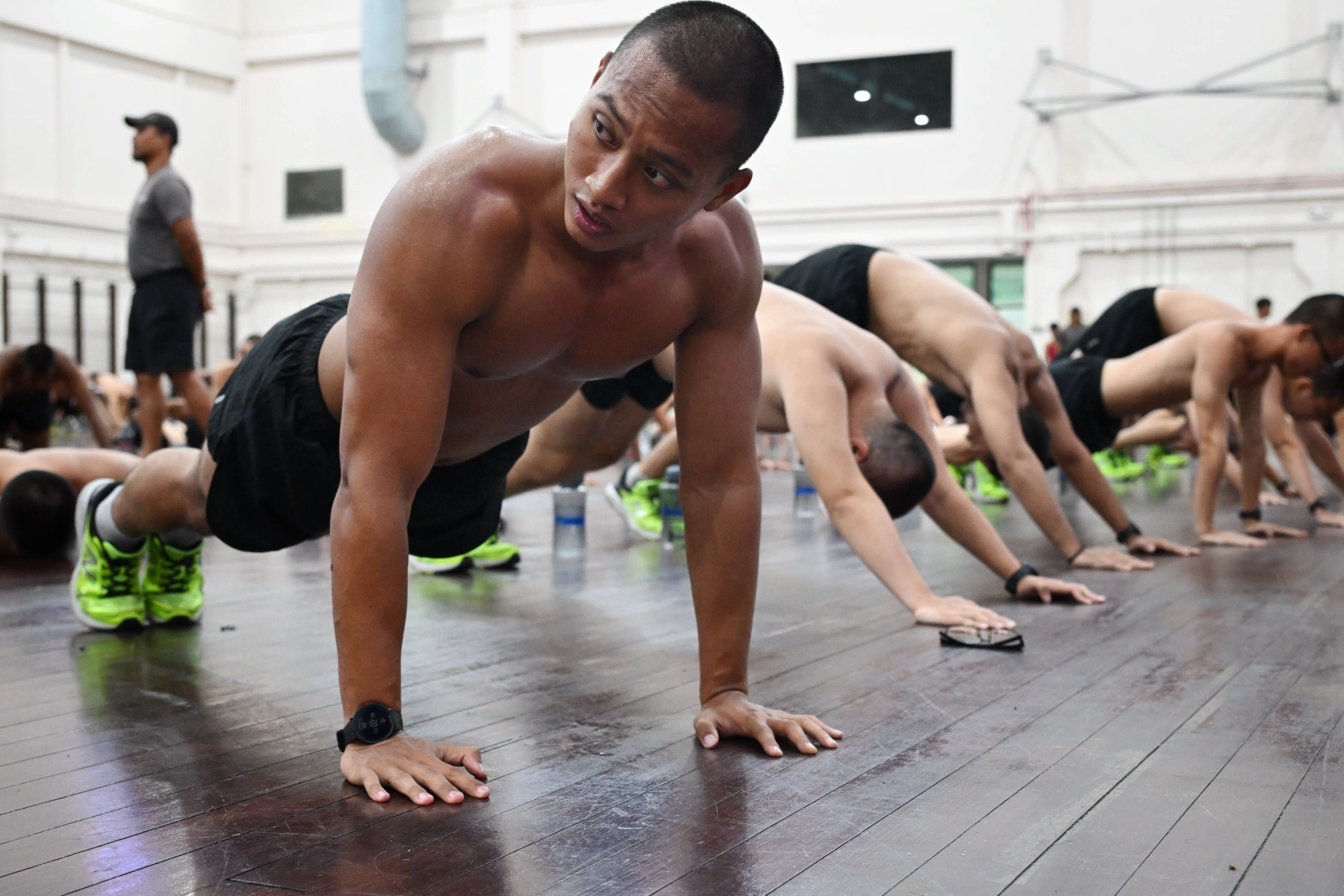 A man wears a smartwatch which tracks his performance while he exercises at the Basic Military Training Centre on Pulau Tekong.