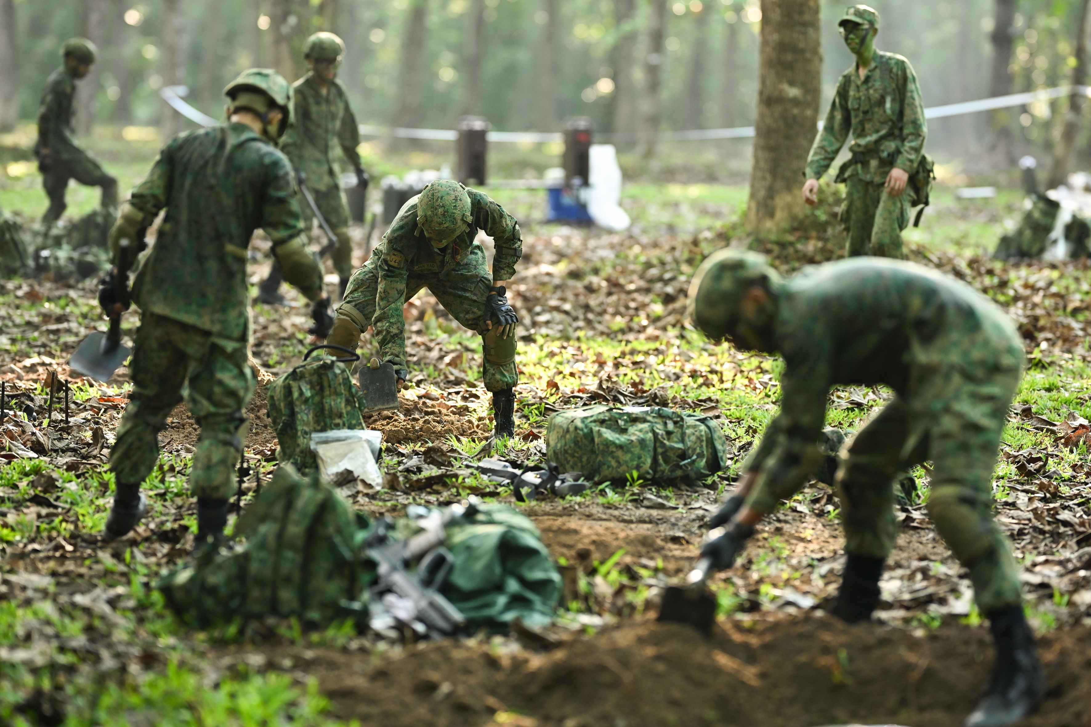 A group of men dig shell scrapes in the jungle on Pulau Tekong.